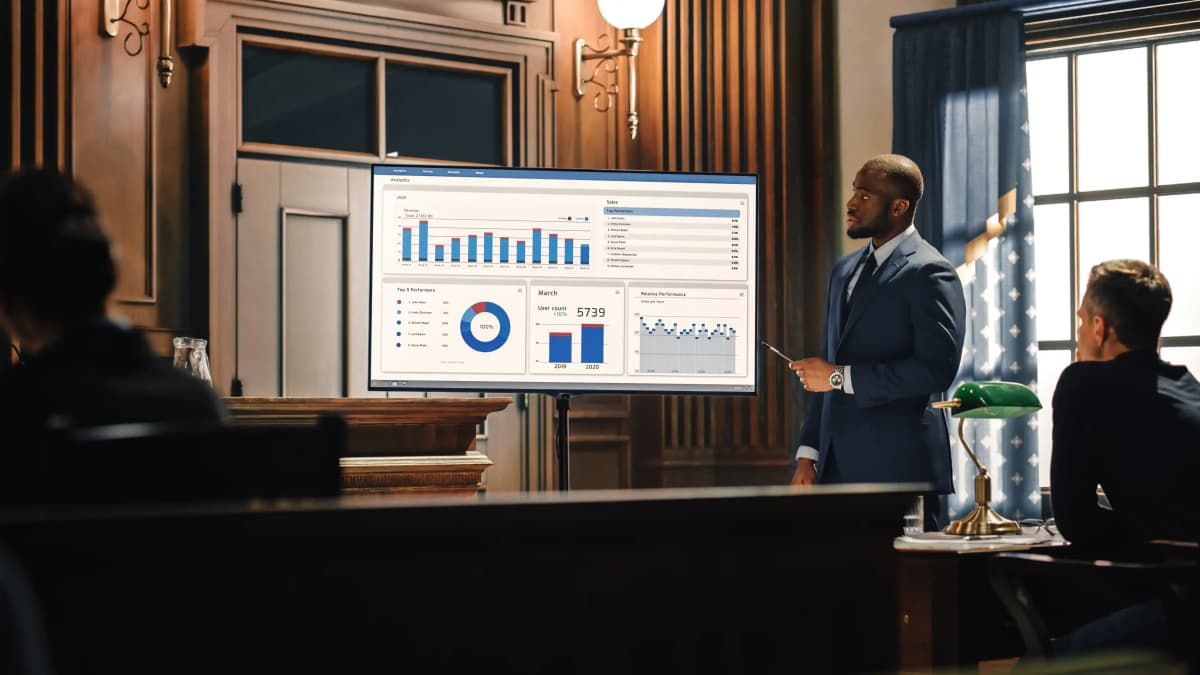 African America male attorney showing evidence on screen in courtroom.