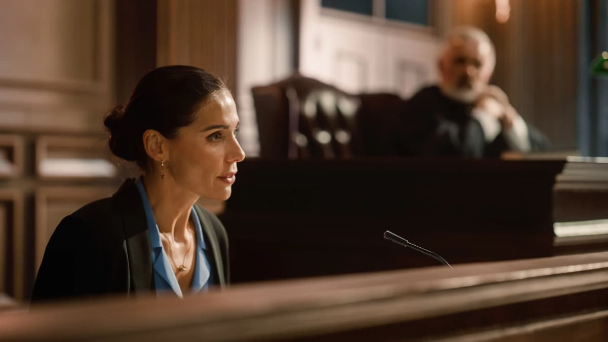 Female witness testifying on the stand in court.